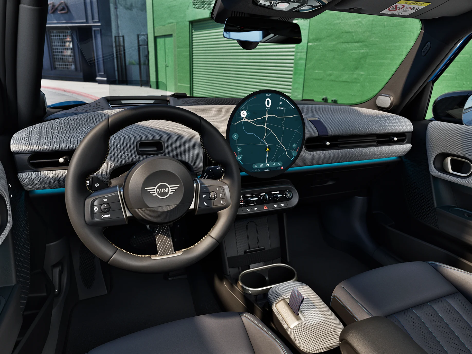 Εσωτερικό του 5θυρου MINI Cooper με εστίαση στο τιμόνι, τον πίνακα οργάνων και τη μονάδα MINI Interaction.