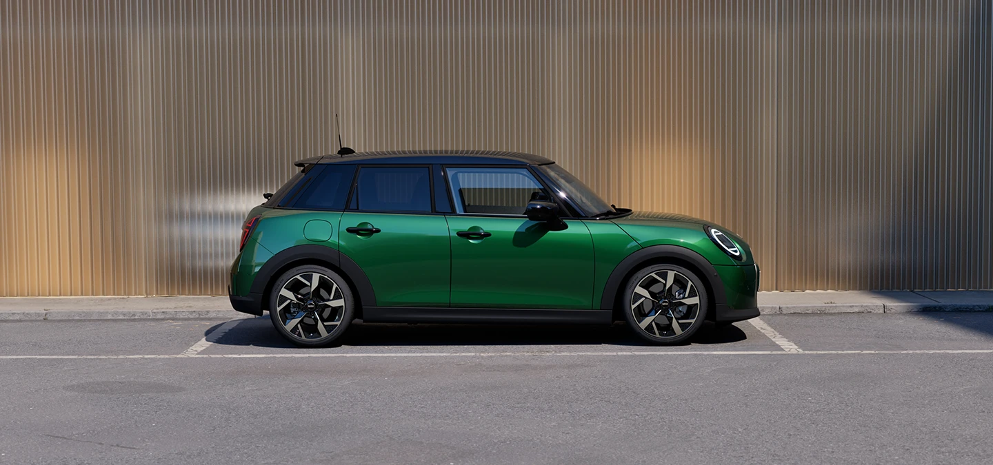 Πλαϊνή όψη του 5θυρου MINI Cooper σε British Racing Green και οροφή σε μαύρο χρώμα, σταθμευμένο.