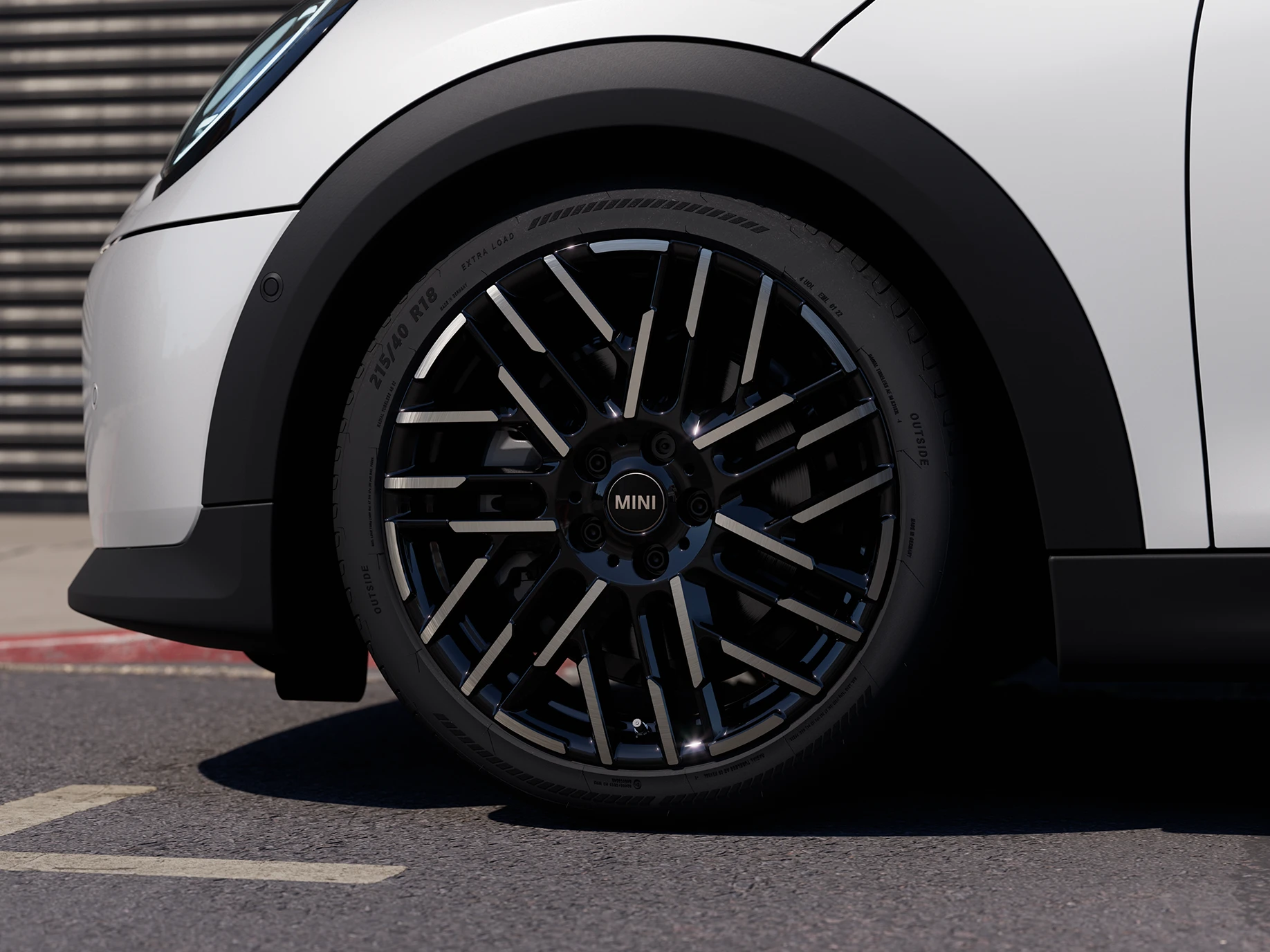 Κοντινή λήψη του 5θυρου MINI Cooper σε Nanuq White με δίχρωμες ζάντες Night Flash Spoke.