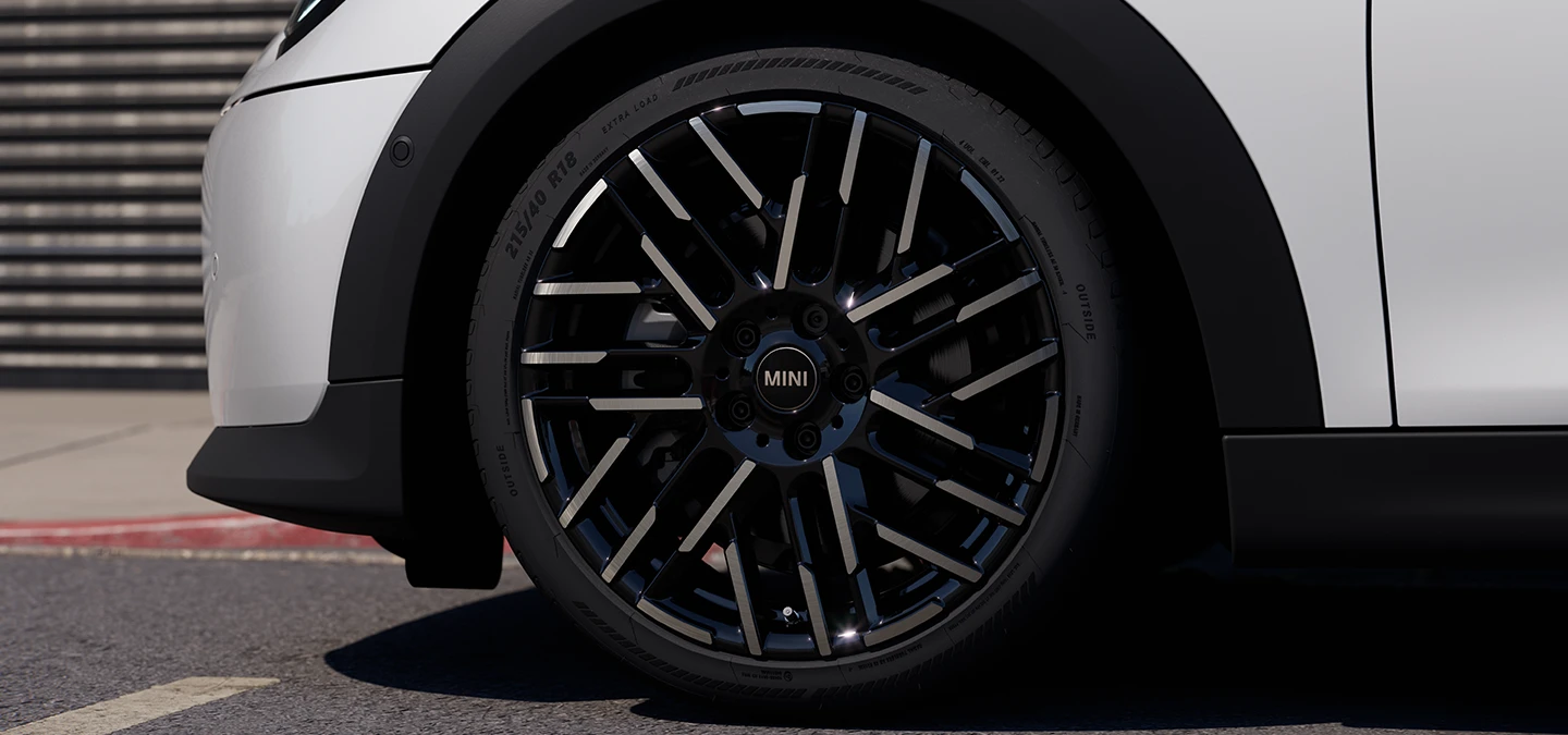 Κοντινή λήψη του 5θυρου MINI Cooper σε Nanuq White με δίχρωμες ζάντες Night Flash Spoke.