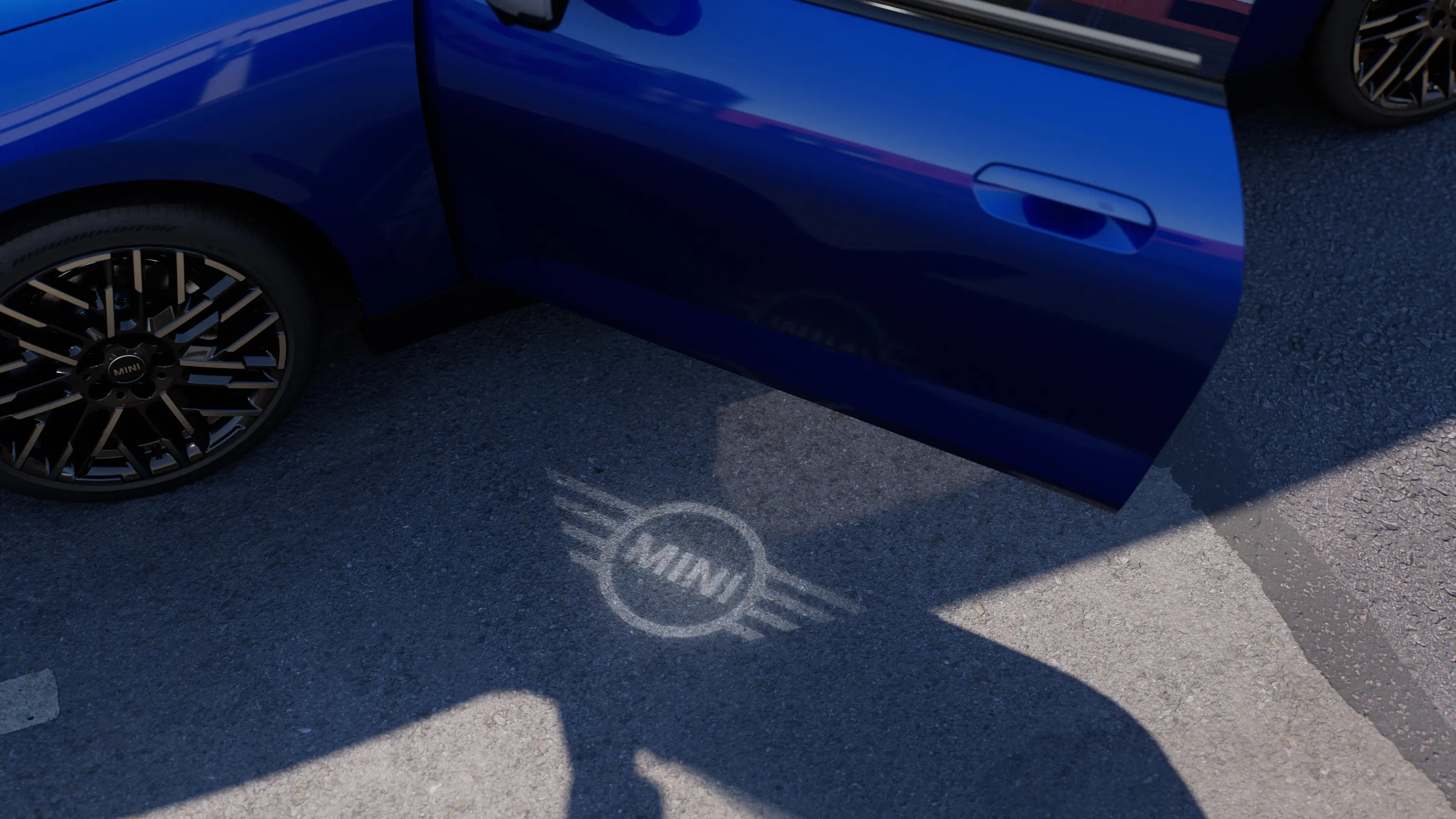 Εξωτερική όψη αμιγώς ηλεκτρικού MINI Cooper με ανοιχτή πόρτα και φωτισμό υποδοχής στο έδαφος με λογότυπο MINI