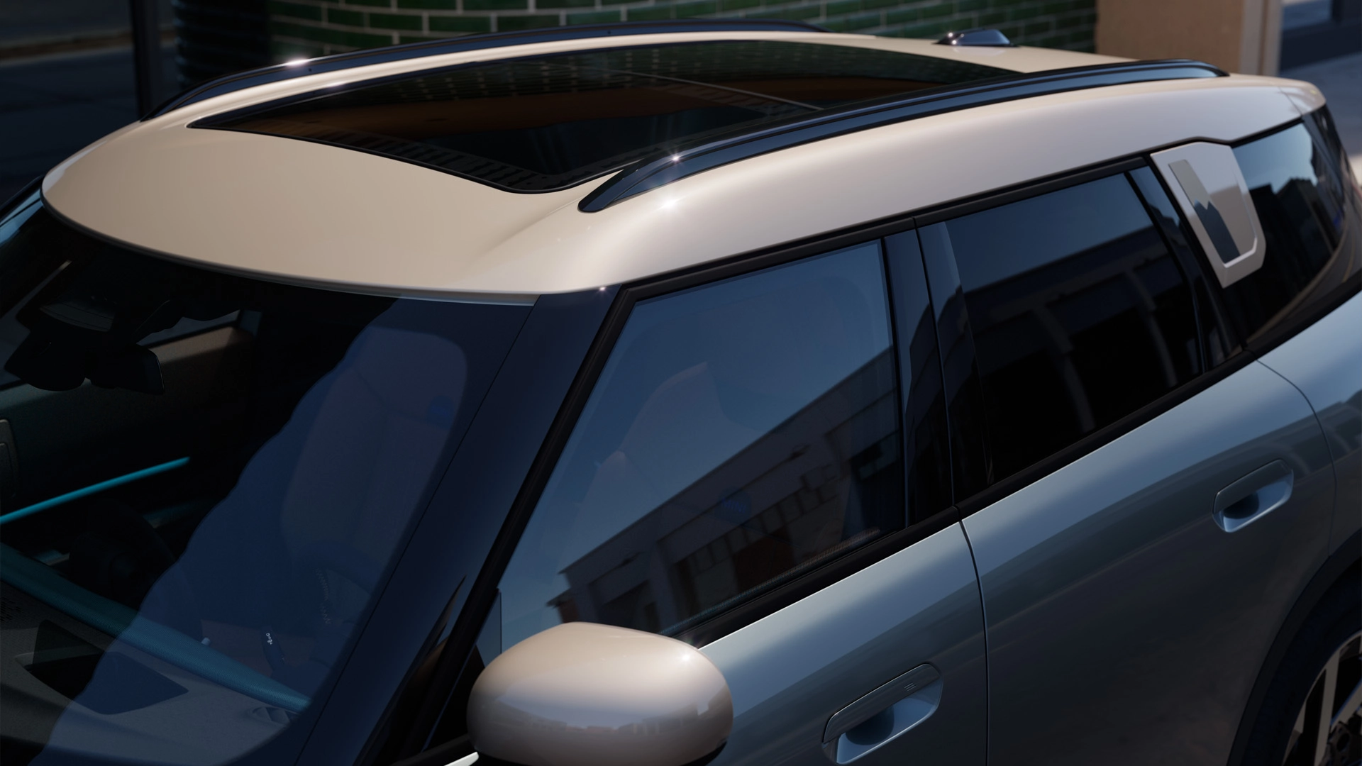 Κάτοψη του MINI Countryman χρώματος Smokey Green με αντίθεση στην οροφή και μεγάλη γυάλινη ηλιοροφή