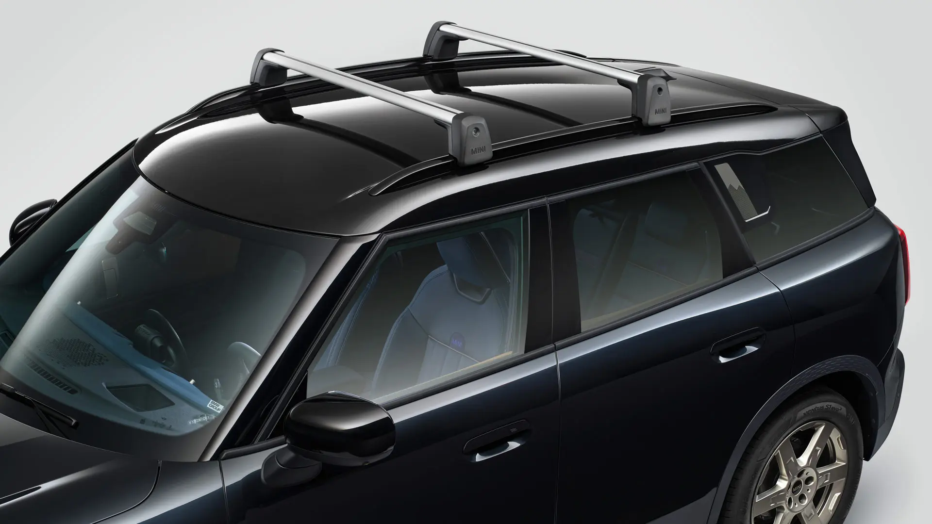MINI Countryman Cooper σε Midnight Black με φορείς μπαρών οροφής MINI – μπροστινή όψη στο πλάι.