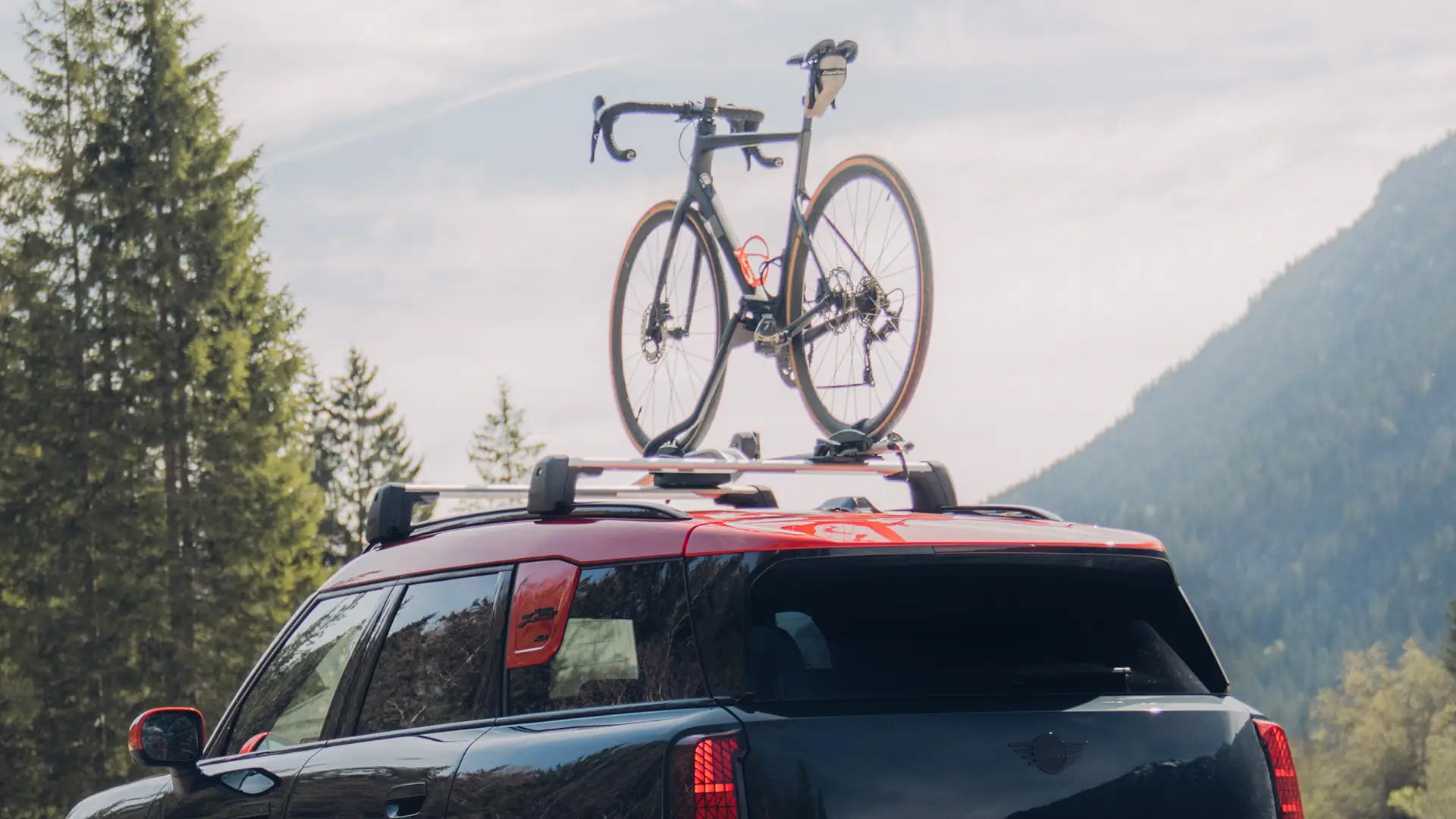 MINI Countryman Cooper σε Black με μπαγκαζιέρα οροφής MINI και βάση οροφής για τη μεταφορά ποδηλάτων MINI με ένα ποδήλατο – πίσω πλευρική όψη