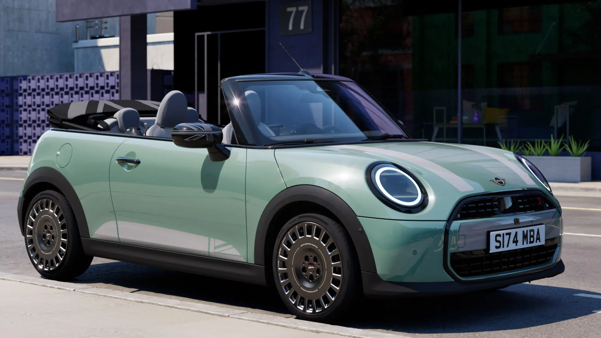 Μπροστινή όψη του MINI Cabrio σε Ocean Wave Green με λευκά αυτοκόλλητα καπό MINI Heritage. 