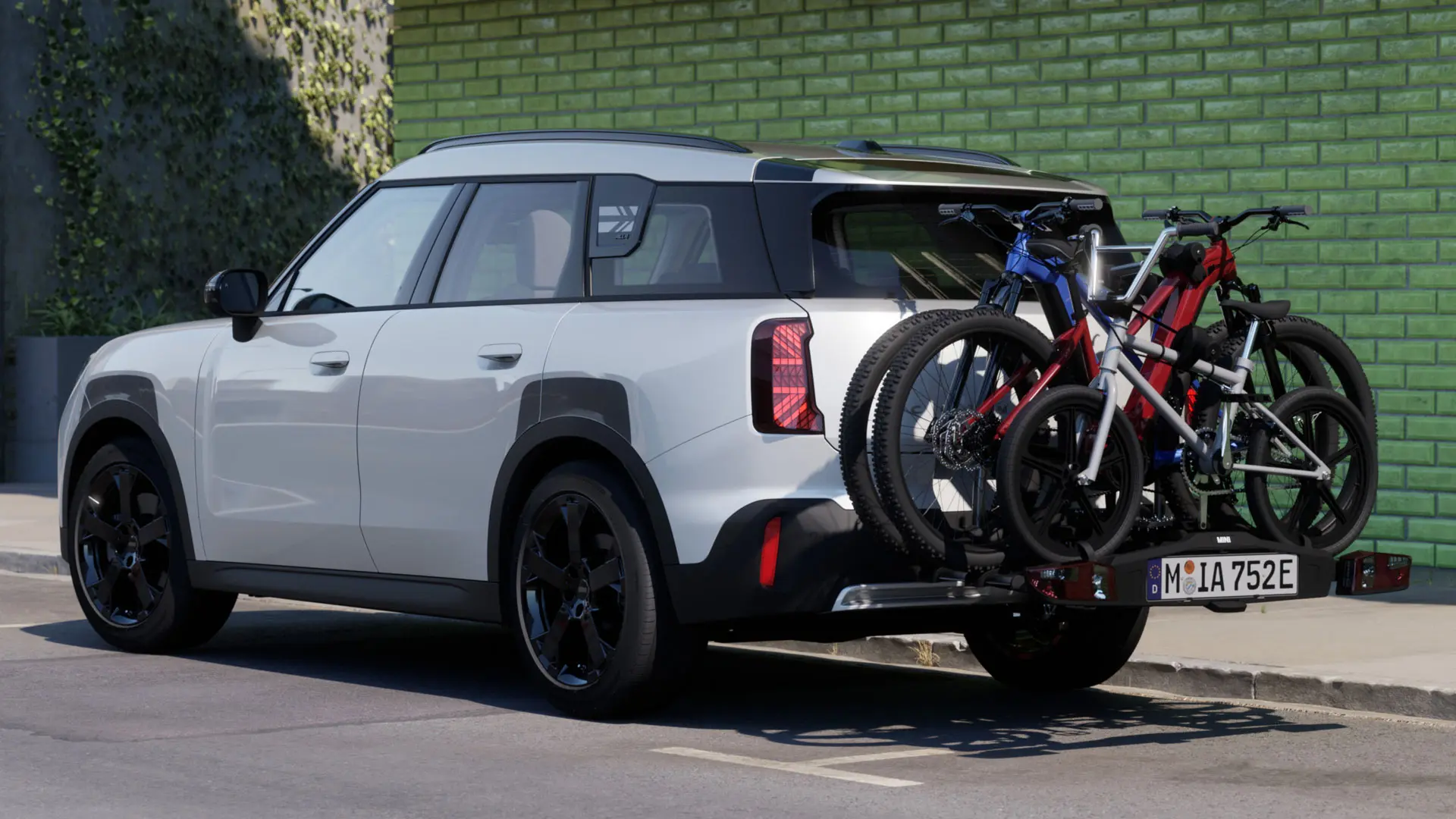 Το MINI Aceman σε Nanuq White εξοπλισμένο με πίσω σχάρα ποδηλάτων MINI Pro 3.0, που μεταφέρει δύο ποδήλατα βουνού και ένα παιδικό ποδήλατο.