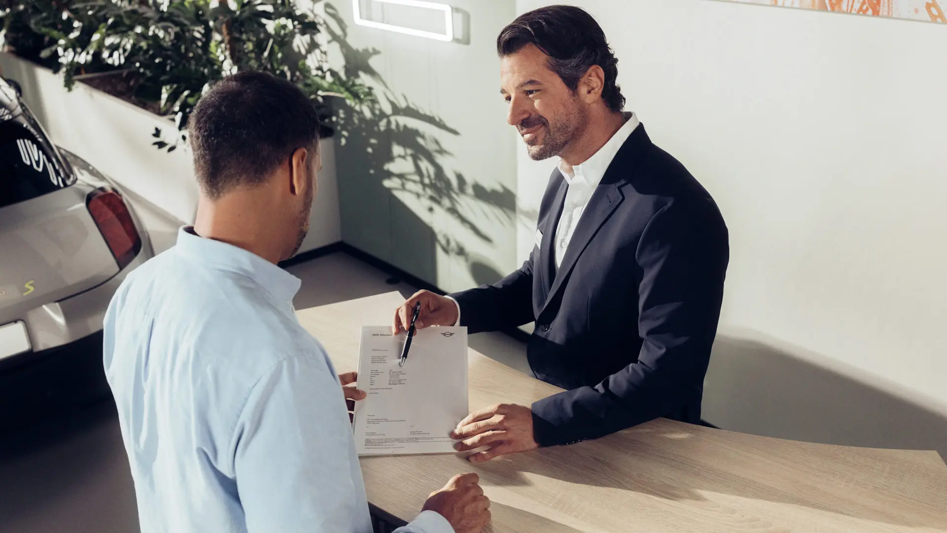 Ένας βοηθός σέρβις Επίσημου Εμπόρου MINI συμβουλεύει έναν πελάτη σχετικά με τις επιλογές ασφάλισης ελαστικών MINI.