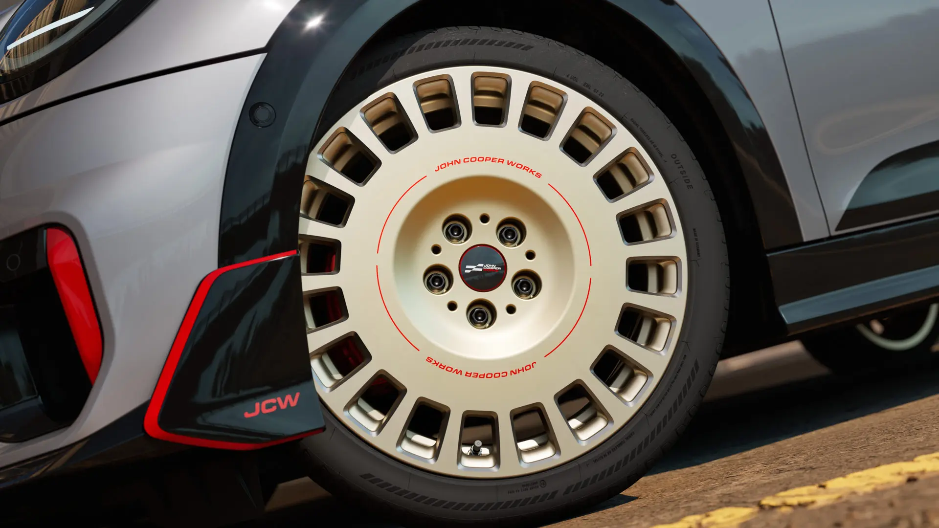 Κοντινό πλάνο των λεπτομερειών της ζάντας 18" JCW Rallye Spoke 964 σε διχρωμία Vibrant Silver, διαμανταρισμένη και μπροστινό winglet.