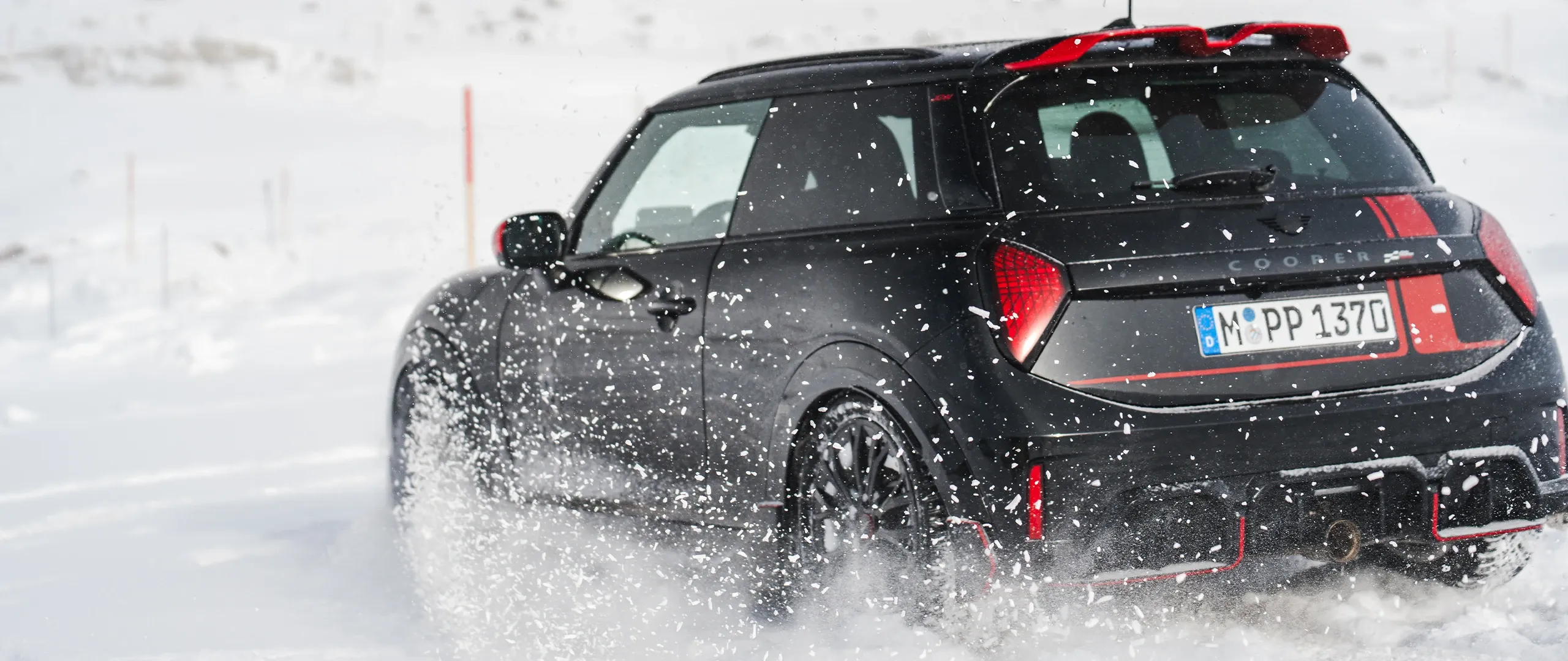 Πίσω όψη ενός MINI Cooper JCW κατά την οδήγηση σε χιόνι