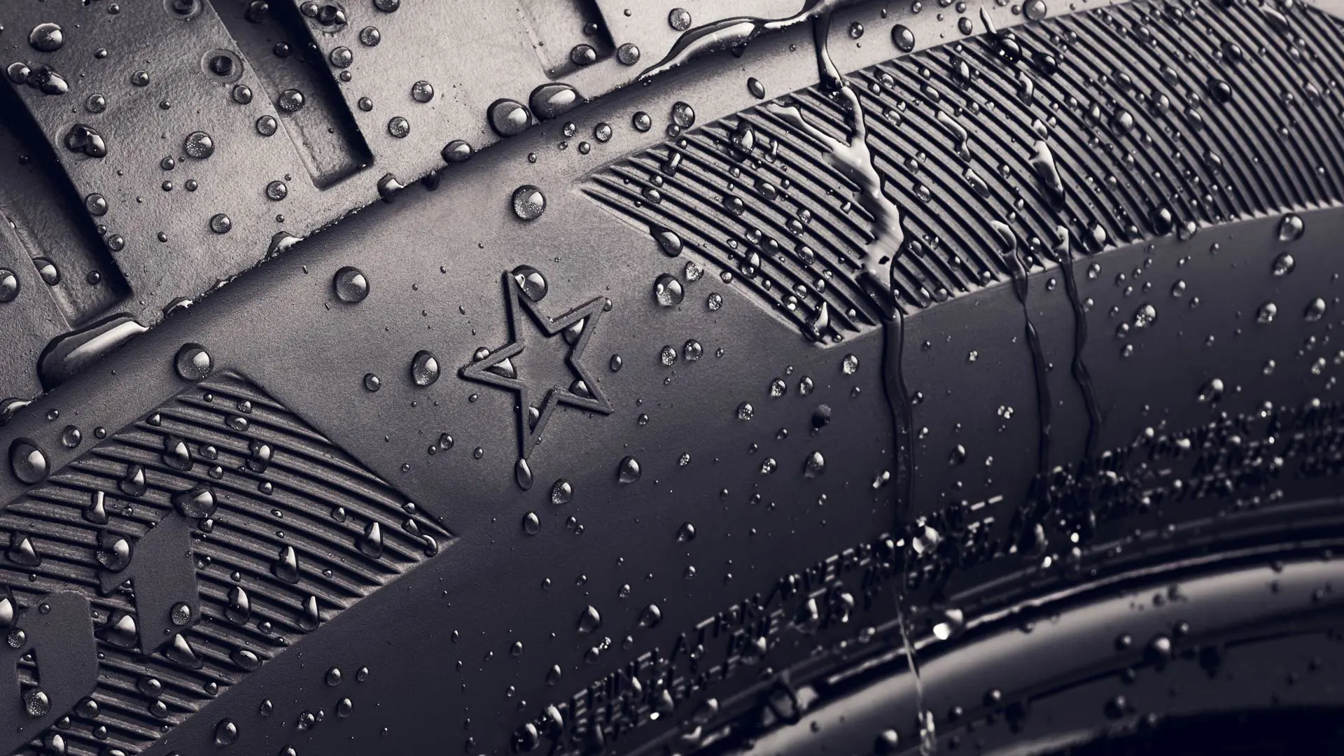 Κοντινό πλάνο του πλευρικού τοιχώματος του ελαστικού με το σύμβολο αστερίσκου, το οποίο υποδεικνύει ότι έχει εγκριθεί για βέλτιστες επιδόσεις στα οχήματα MINI. 