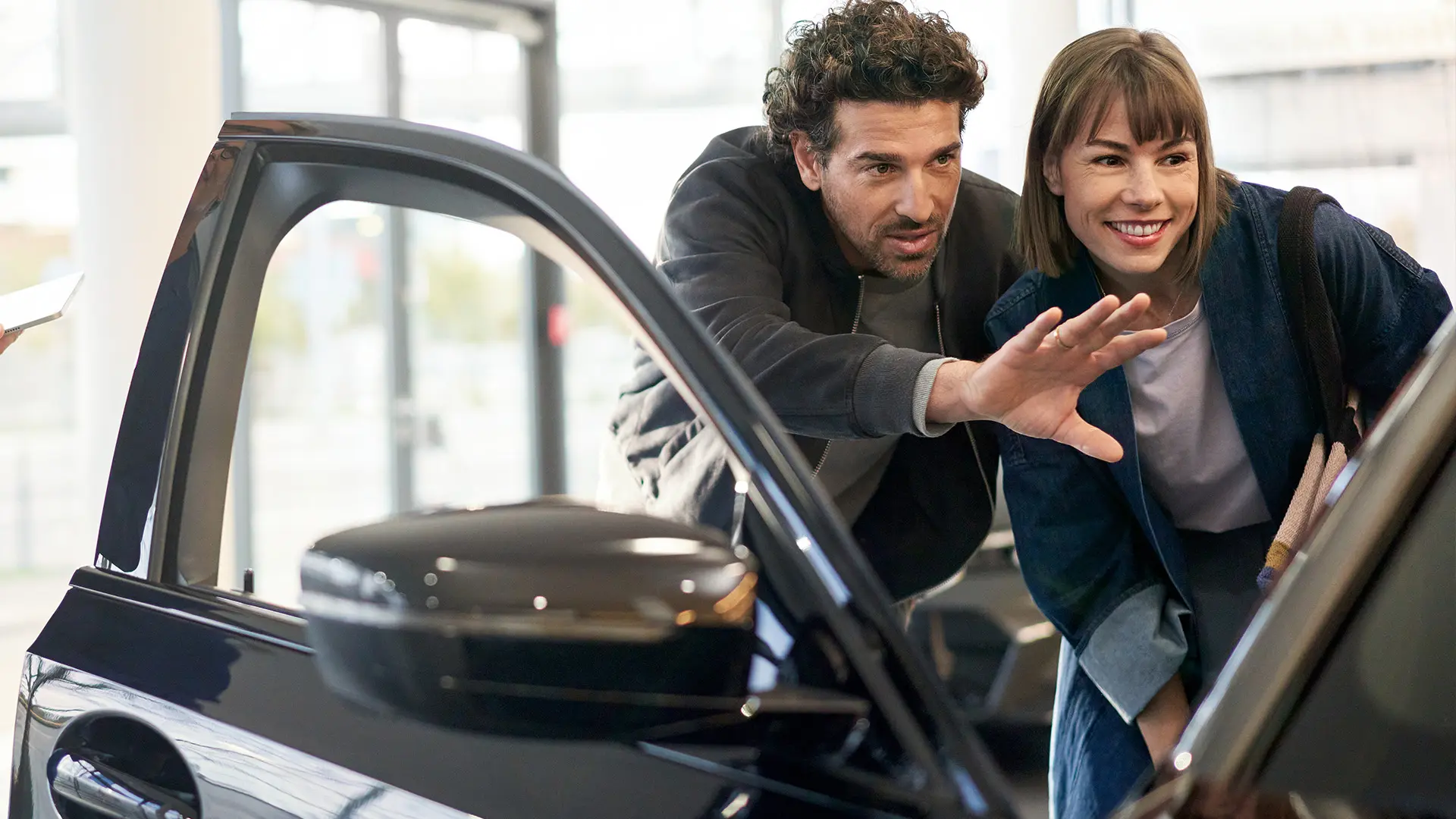 MINI μέσα σε αντιπροσωπία MINI με σύμβουλο πωλήσεων να συζητά με πελάτη και να εξηγεί τα χαρακτηριστικά εσωτερικού εξοπλισμού.