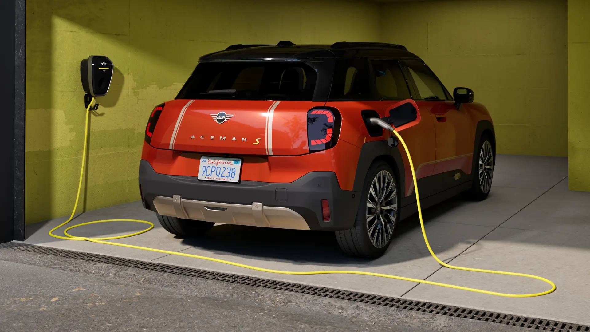 Αμιγώς ηλεκτρικό MINI Aceman S φορτίζει σε MINI Wallbox Plus, πίσω όψη, σταθμευμένο σε γκαράζ.