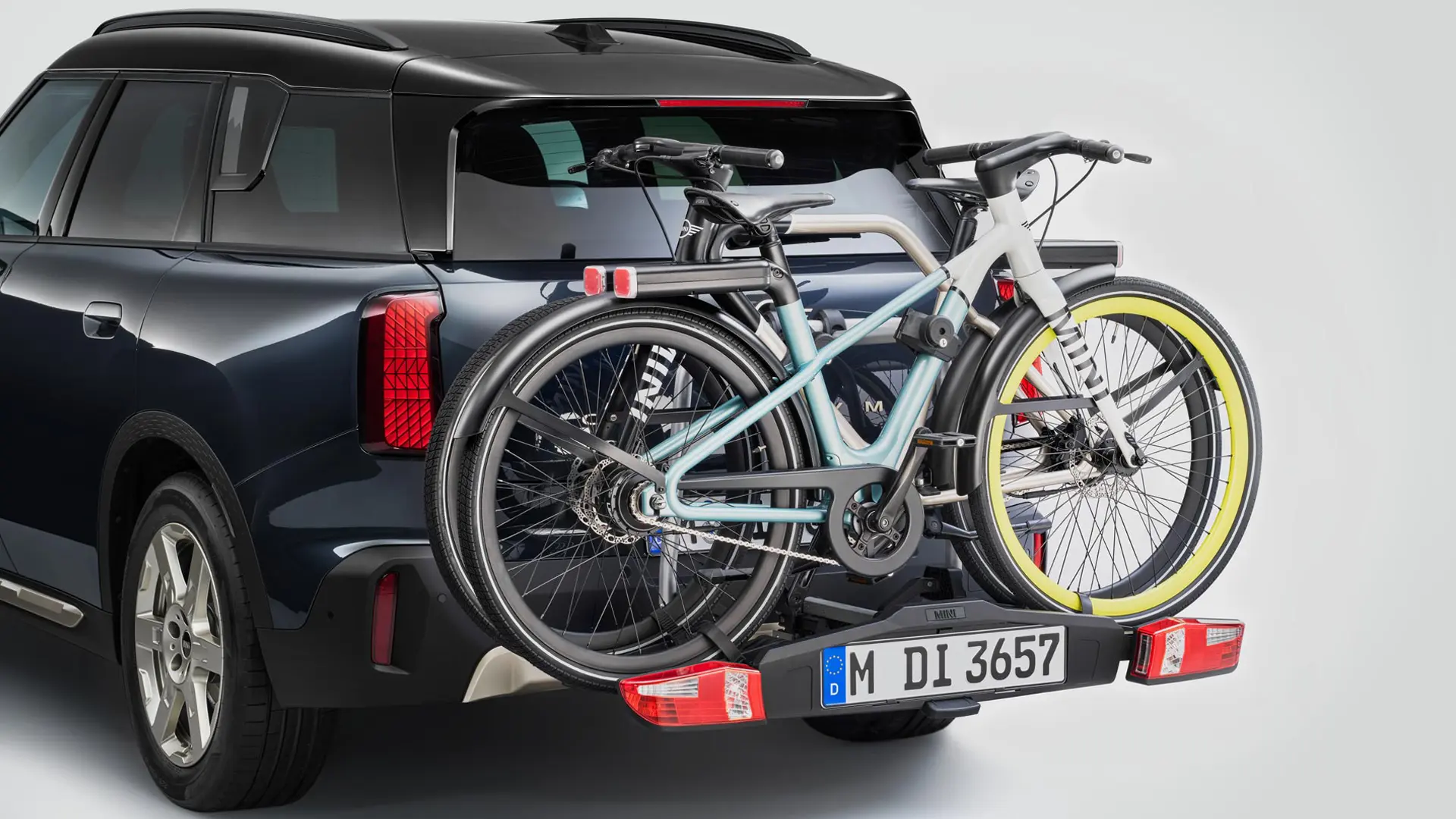 MINI Countryman σε μαύρο χρώμα, με πίσω σύστημα μεταφοράς ποδηλάτων και τοποθετημένα δύο ποδήλατα mountain bike, πίσω όψη.