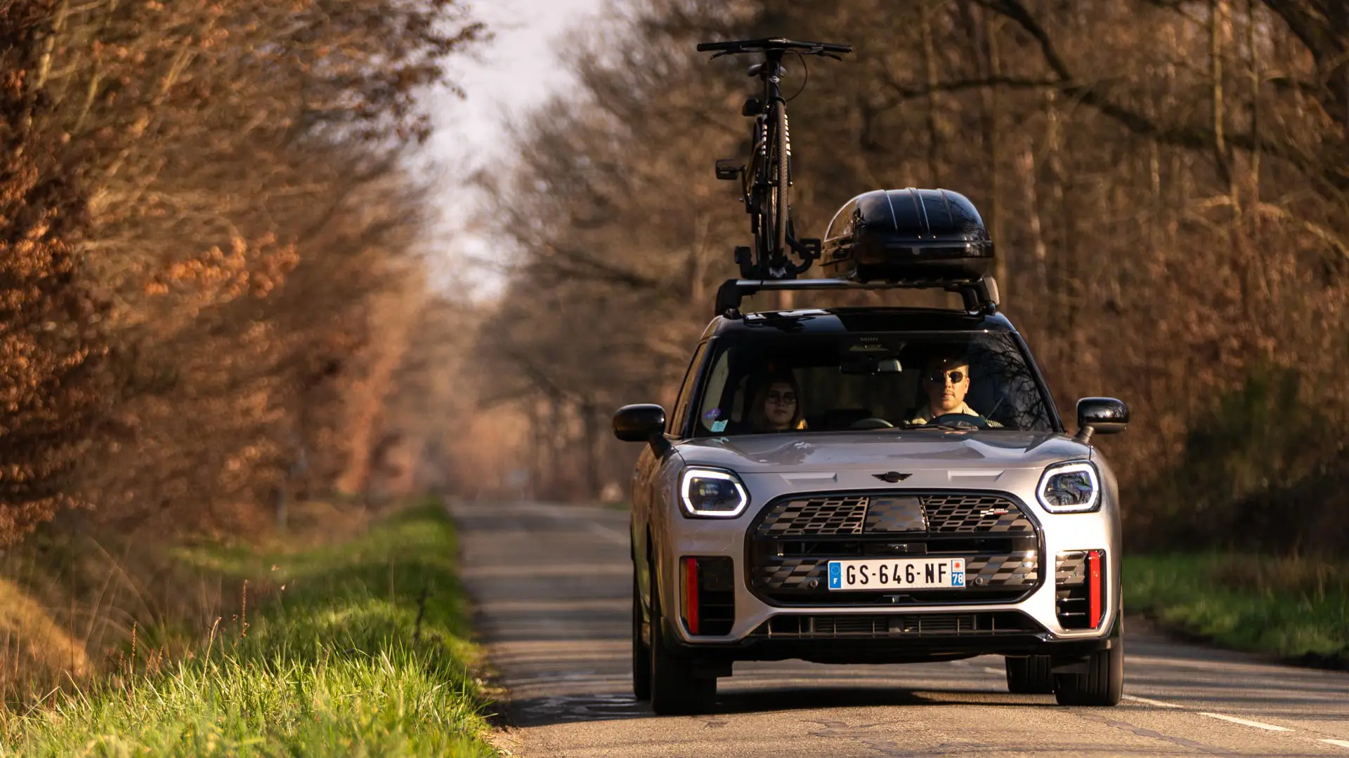 MINI Countryman με μπαγκαζιέρα οροφής κινούμενο σε δρόμο.