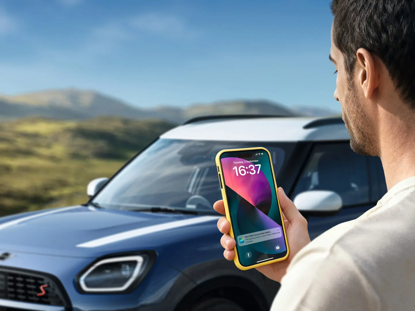 Ένας οδηγός MINI Countryman χρησιμοποιεί την εφαρμογή MINI App για να επικοινωνήσει με τη MINI Roadside Assistance. 
