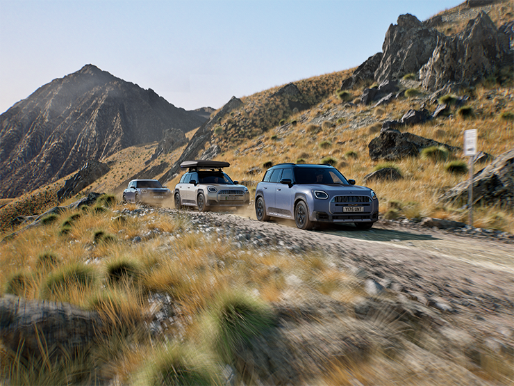 Εικόνα με πολλά μοντέλα MINI Countryman Untamed Edition να κινούνται εκτός δρόμου σε ορεινή διαδρομή.