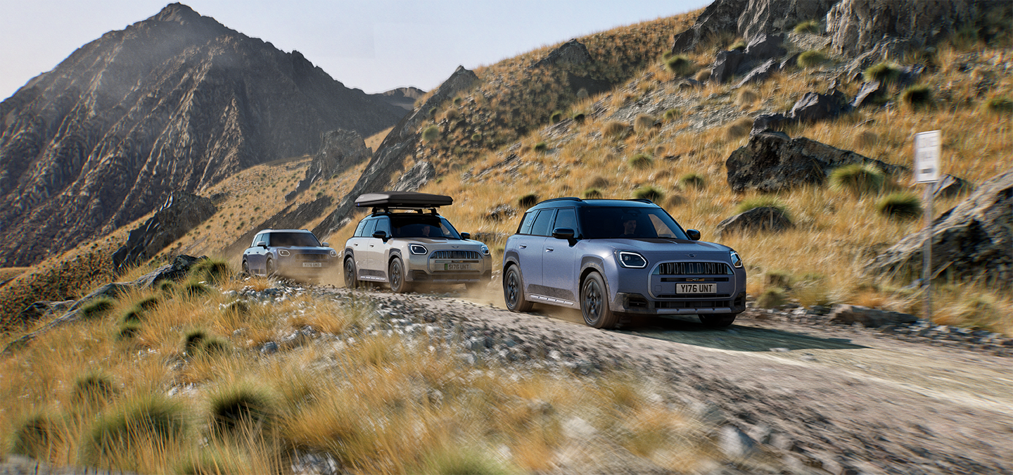 Εικόνα με πολλά μοντέλα MINI Countryman Untamed Edition να κινούνται εκτός δρόμου σε ορεινή διαδρομή.
