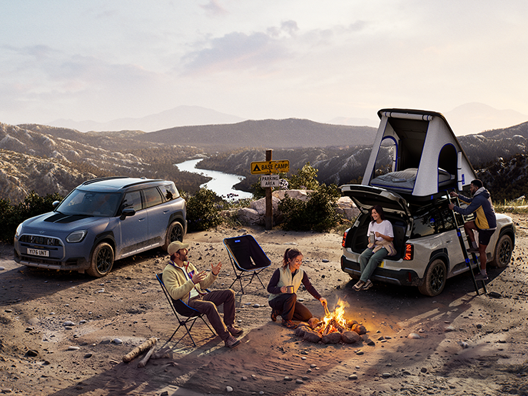 Εικόνα με δύο MINI Countryman Untamed Edition σε βουνό το ηλιοβασίλεμα.