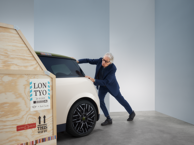 Πίσω όψη του αμιγώς ηλεκτρικού MINI Cooper Paul Smith Edition σε Inspired White με τον Paul Smith πίσω από το αυτοκίνητο