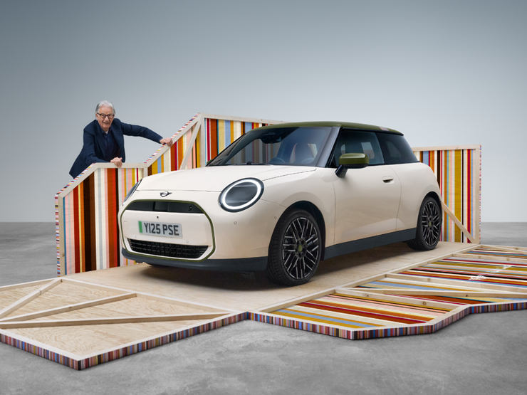 Μπροστινή λήψη του αμιγώς ηλεκτρικού MINI Cooper Paul Smith Edition σε Inspired White με τον σχεδιαστή Paul Smith